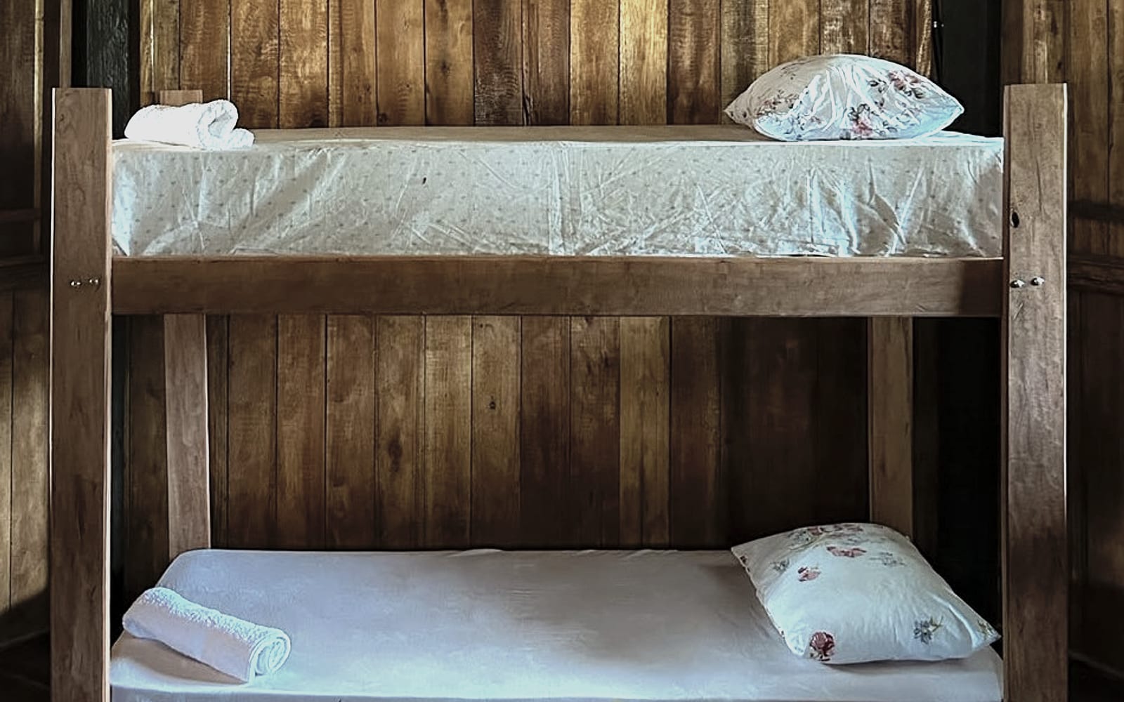 Beliche de madeira do Hostel Tupinambá, com roupa de cama e toalhas