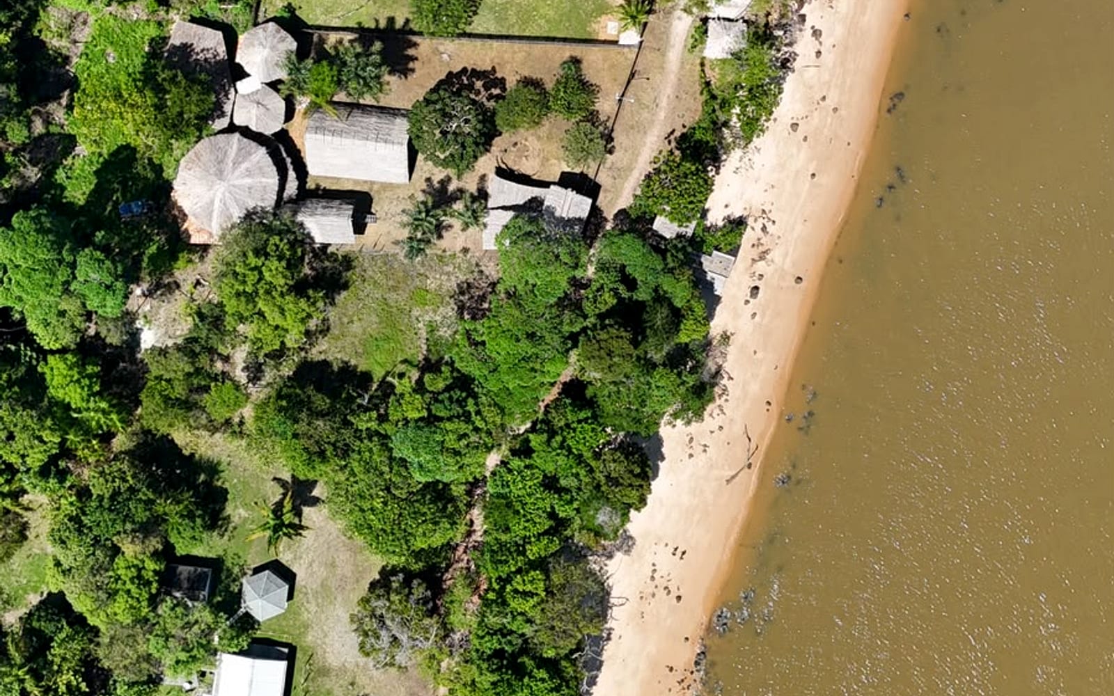 Vista aérea da Praia Funda com a pousada entre a mata e a areia