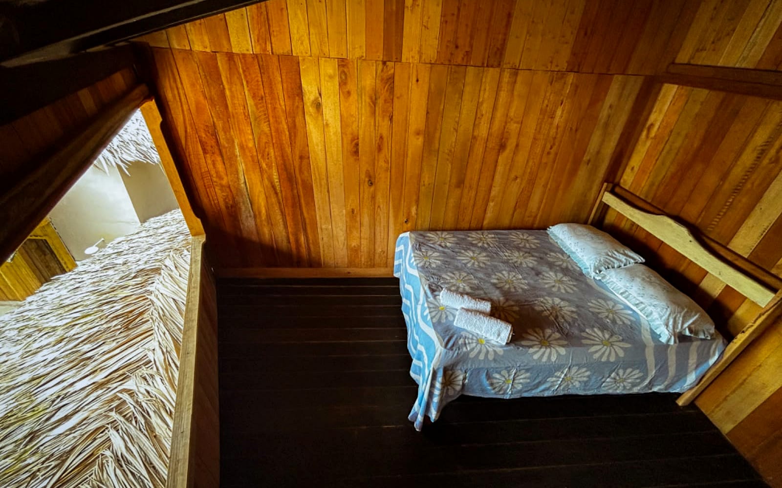 Cama sob a cobertura de palha, com abertura ampla para o exterior